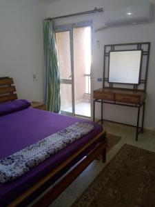 a bedroom with a bed and a dresser and a tv at Chalet duplex in El Alamein