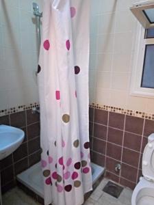a bathroom with a shower curtain with pink and brown dots at Chalet duplex in El Alamein +18 photos