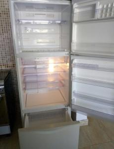an empty refrigerator with its door open in a kitchen at Chalet duplex in El Alamein