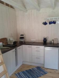 cocina con armarios blancos y encimera en Tirbi Holiday House, en Kassari