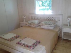 1 dormitorio con 1 cama con 2 almohadas y ventana en Tirbi Holiday House, en Kassari