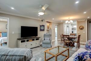a living room with a television and a dining room at Bend in the Road 2003 in Seabrook Island
