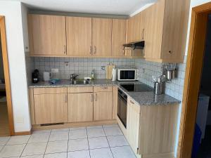 a kitchen with wooden cabinets and a sink and a microwave at Ferienwohnung Ichtys in Hasliberg