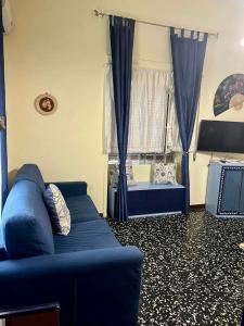 sala de estar con sofá azul y ventana en B&B Fabiola, en Pompeya