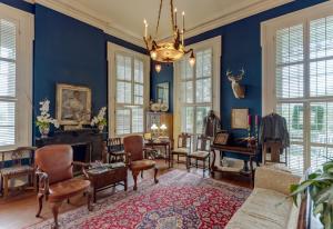 a living room with blue walls and a chandelier at The Duff Green Mansion in Vicksburg