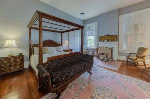 um quarto com uma cama de dossel e uma sala de estar em The Duff Green Mansion em Vicksburg