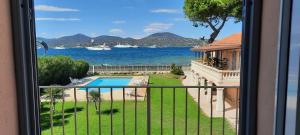 een balkon met uitzicht op een huis en een zwembad bij Villa Playa del Sol - B1e1 in Saint-Tropez