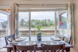 a dining room with a table and chairs and a large window at The Bullpen 129 in Neskowin