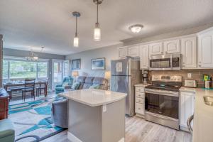 a kitchen with white cabinets and appliances and a living room at The Dugout #128 in Neskowin