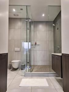 a bathroom with a glass shower and a toilet at Top Floor Penthouse - Overlooking Times Square Casino in Pretoria