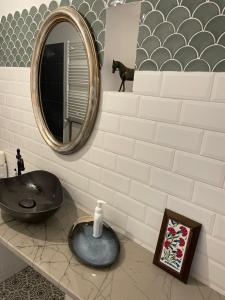 baño con lavabo negro y espejo en Casa Din Targ en Horezu