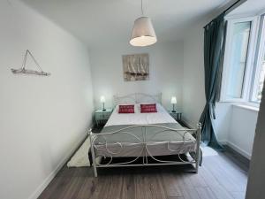 ein Schlafzimmer mit einem Bett mit roten Kissen darauf in der Unterkunft Vila Mila Volosko Opatija in Opatija