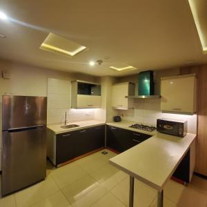 a kitchen with a stainless steel refrigerator and a counter at CosmoStay Islamabad, Bahria Town in Rawalpindi