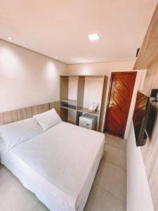 um quarto com uma cama branca num quarto em Pousada Tartarugas Marinhas em Fernando de Noronha