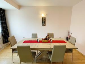 een eetkamer met een houten tafel en stoelen bij Spacious and Bright Maisonette Varna Center in Varna