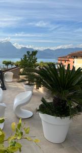 a row of white pots with plants on a patio at Suite La Castellana in Torri del Benaco