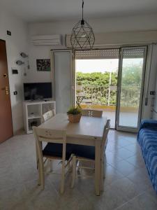 y sala de estar con mesa de comedor y sillas. en Riviera la lanterna en Scoglitti