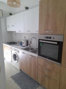 a kitchen with a sink and a washing machine at Riviera la lanterna in Scoglitti