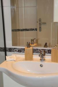 un bagno con un lavandino e un grande specchio di Studio Nefeli a Archangelos