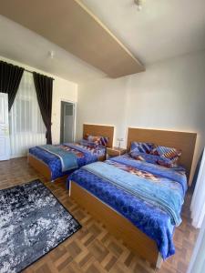 1 Schlafzimmer mit 2 Betten und einem Teppich in der Unterkunft Homestay Lidah Buaya 3 Syariah in Banjarnegara