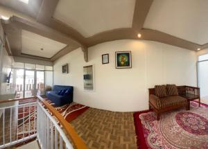 a living room with a couch and a chair at Homestay Lidah Buaya 3 Syariah in Banjarnegara