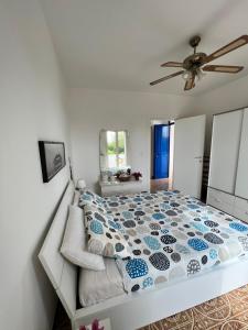 sypialnia z łóżkiem i wentylatorem sufitowym w obiekcie AL PEPE NERO - Casa in campagna a soli 5 minuti dal mare w mieście Polignano a Mare