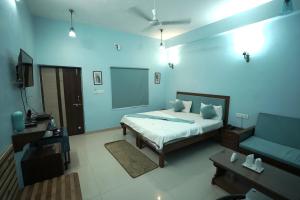 Habitación azul con cama y sofá en Devendragarh Palace - Luxury Paying Guest House, en Udaipur