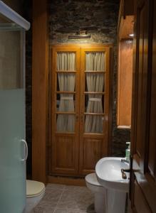 baño con lavabo y puerta de madera en Apartamentos Rurales Las Mestas, en Puenteciella