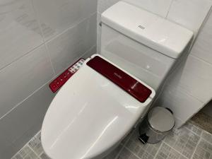 um WC branco numa casa de banho com controlo remoto em Cozy Sinchon 2548 em Jeju