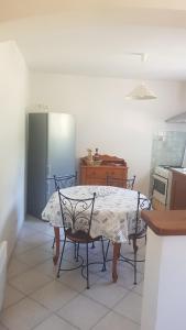 a kitchen with a table and two chairs and a refrigerator at Bas de Villa chez Mr.Girolami Dominique in Bastia