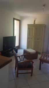 a living room with a tv and a couch and a chair at Bas de Villa chez Mr.Girolami Dominique in Bastia