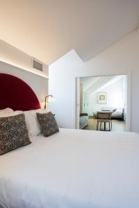 - une chambre avec un grand lit blanc et une table dans l'établissement Villa Rossella, à Locarno