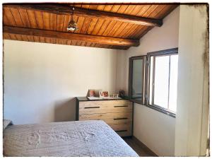 - une chambre avec un lit, une fenêtre et une commode dans l'établissement Casa DiEle, à Castelbuono