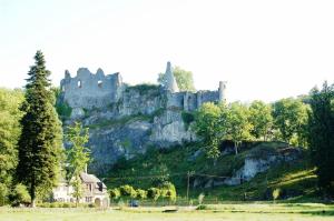 un château au sommet d'une colline avec une maison dans l'établissement B&B Chession, à Falaën