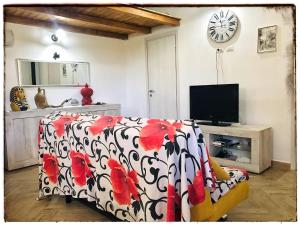 - un salon avec un lit et une télévision dans l'établissement Casa DiEle, à Castelbuono