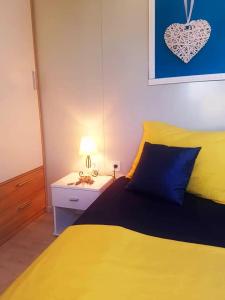 1 dormitorio con cama amarilla y mesita de noche en Eden Lady Mobile Home, Croatia, Drage, en Drage