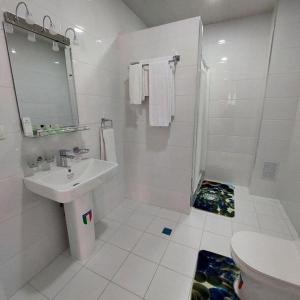 Baño blanco con lavabo y aseo en Queens 2 hotel en Tashkent