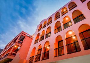 a building with orange and white walls and windows at Khaleej Mass Hotel Patong in Patong Beach +70 photos