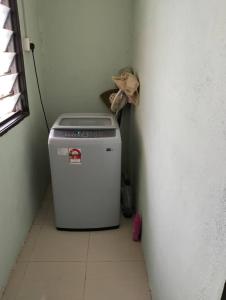 eine kleine Waschmaschine in einer Ecke eines Zimmers in der Unterkunft Homestay Zulaika Kota Aur in Kepala Batas