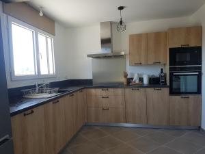 kuchnia z drewnianymi szafkami i oknem w obiekcie Gîte paisible rénové w mieście Hagetmau