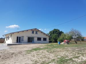 dom z mężczyzną stojącym przed nim w obiekcie Gîte paisible rénové w mieście Hagetmau