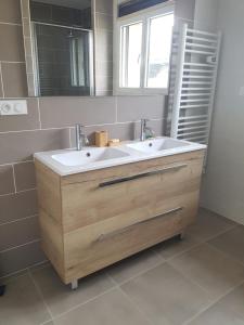 łazienka z umywalką i lustrem w obiekcie Gîte paisible rénové w mieście Hagetmau
