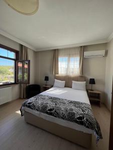 a bedroom with a large bed and a large window at Kerpe Diem Otel in Kerpe