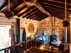 a living room with a blue couch and a stone wall at Palheiro Mezio in Mezio