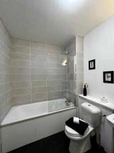 La salle de bains est pourvue d'une baignoire, de toilettes et d'un lavabo. dans l'établissement Superbe appartement confortable, proche centre ville, à Rennes