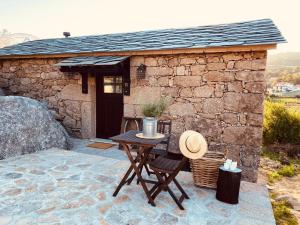 a small stone building with a table in front of it at Palheiro Mezio in Mezio +19 photos