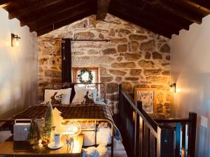 a bedroom with a bed in a stone wall at Palheiro Mezio in Mezio