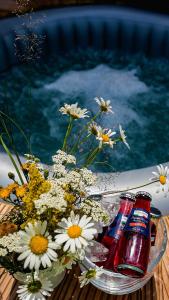 ein Blumenstrauß und zwei Flaschen Soda auf dem Tisch in der Unterkunft Acasă Straja - Casa Nordică in Lupeni