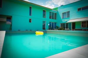 a swimming pool in front of a building with a yellow object in the water at Pensiunea Dolce in Timişoara