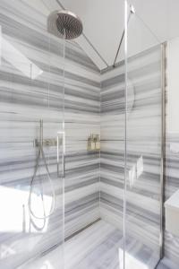 uma casa de banho com um chuveiro e uma porta de vidro em Villa Rossella em Locarno